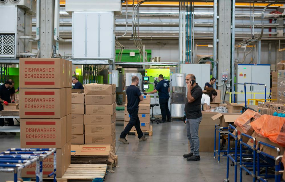Workers moving stock and packing boxes on a warehouse floor